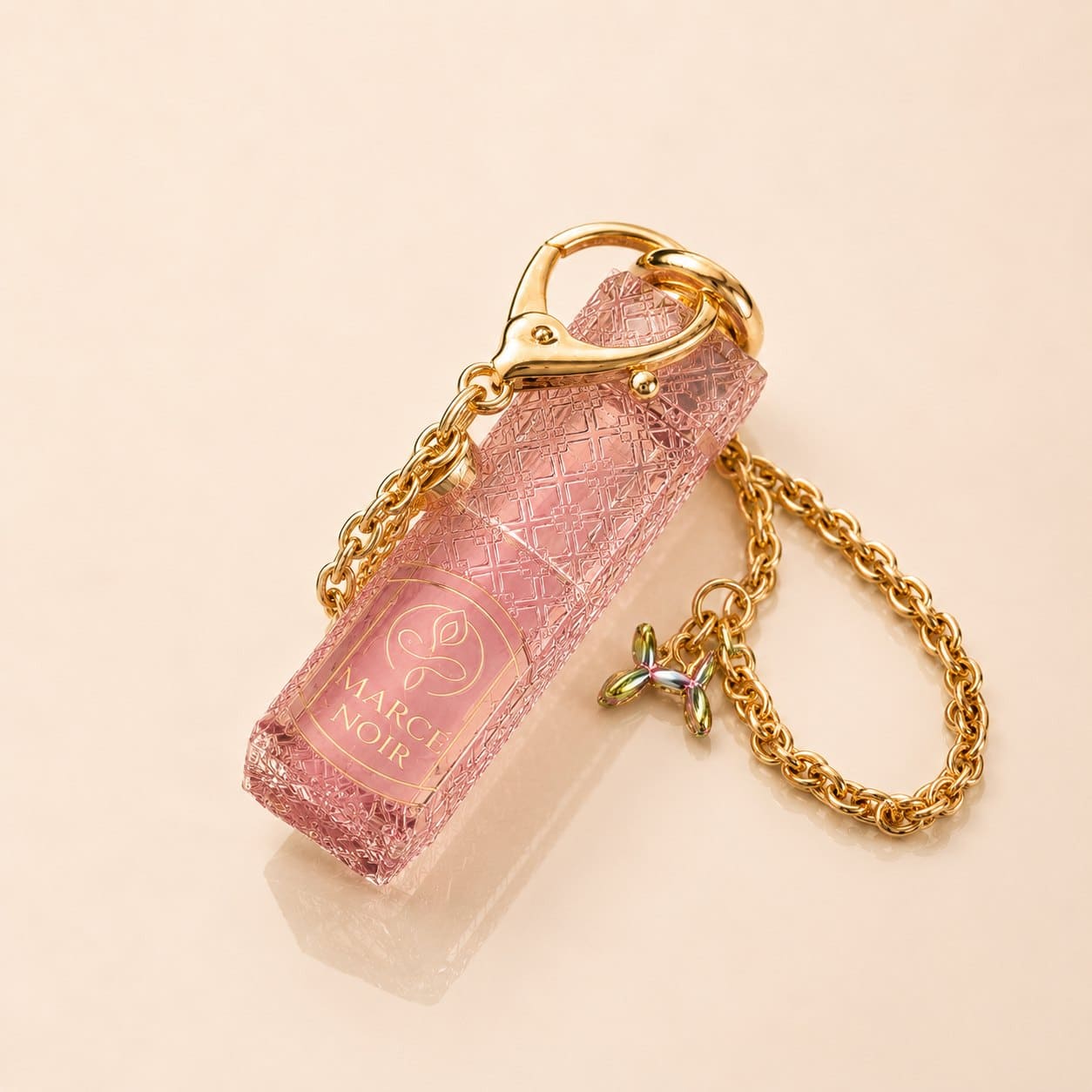 Lip Oil Marcé Noir en cristal labrado rosa con cadena dorada — el frasco con su cadena