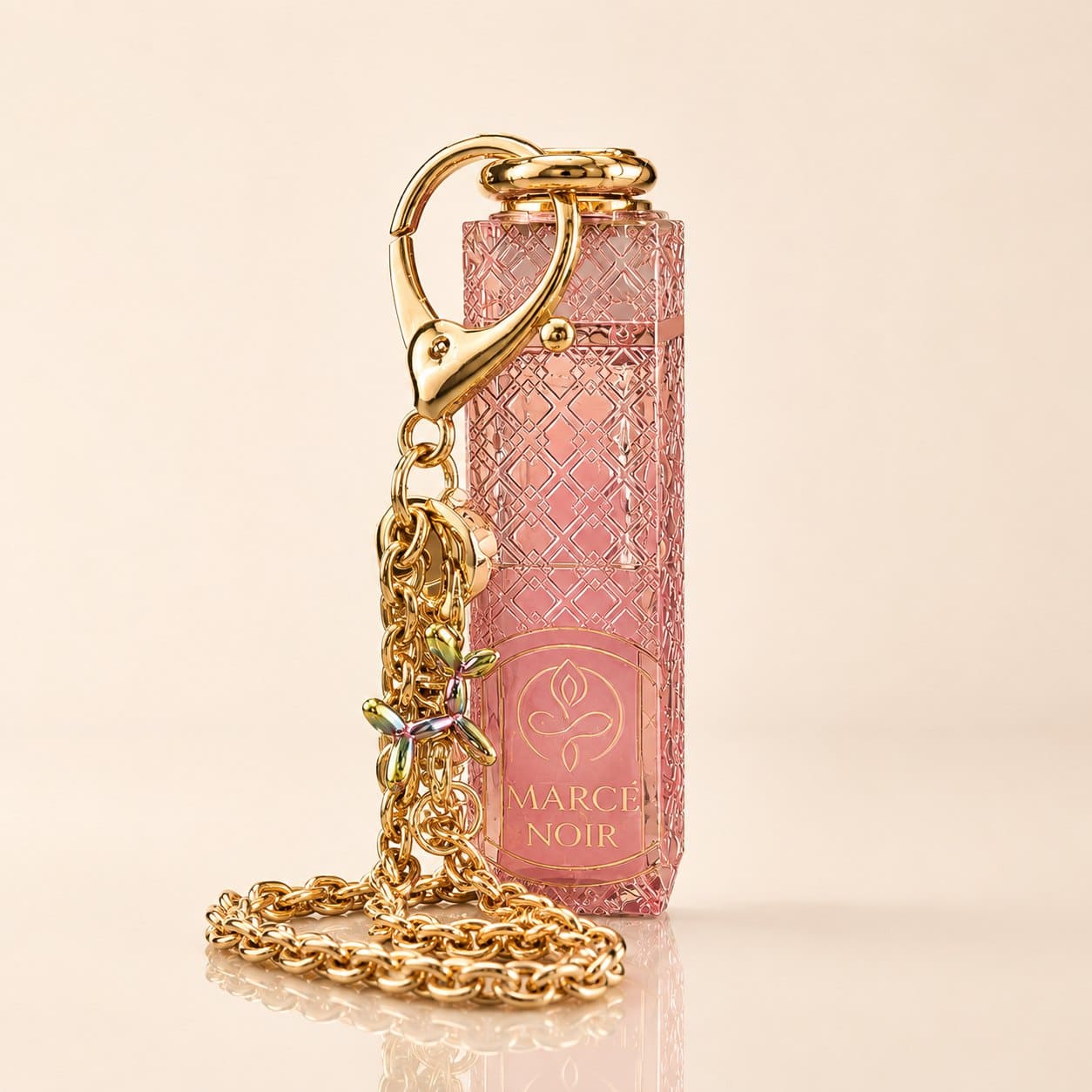 Lip Oil Marcé Noir en cristal labrado rosa con cadena dorada — la pieza completa